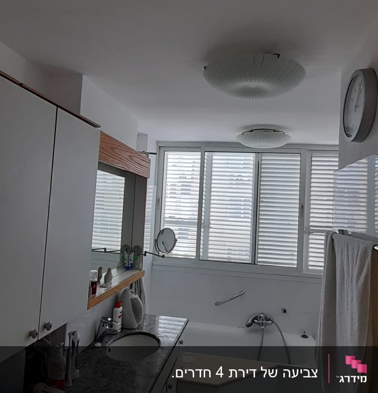 חדר אמבטיה עם כיור, מראה ואמבטיה